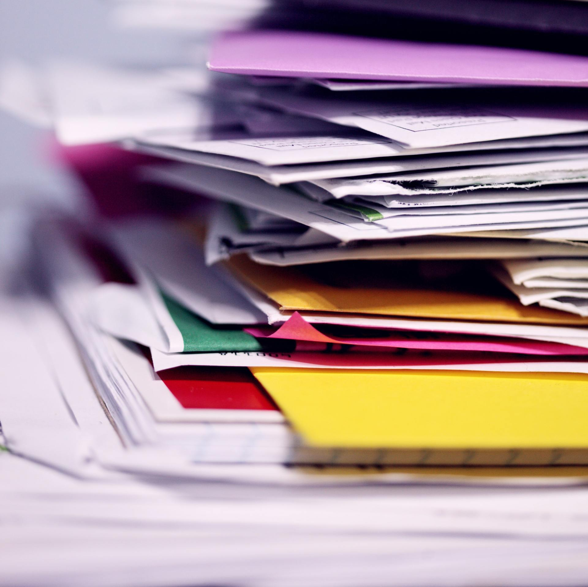 a pile of colorful papers and envelopes on a table