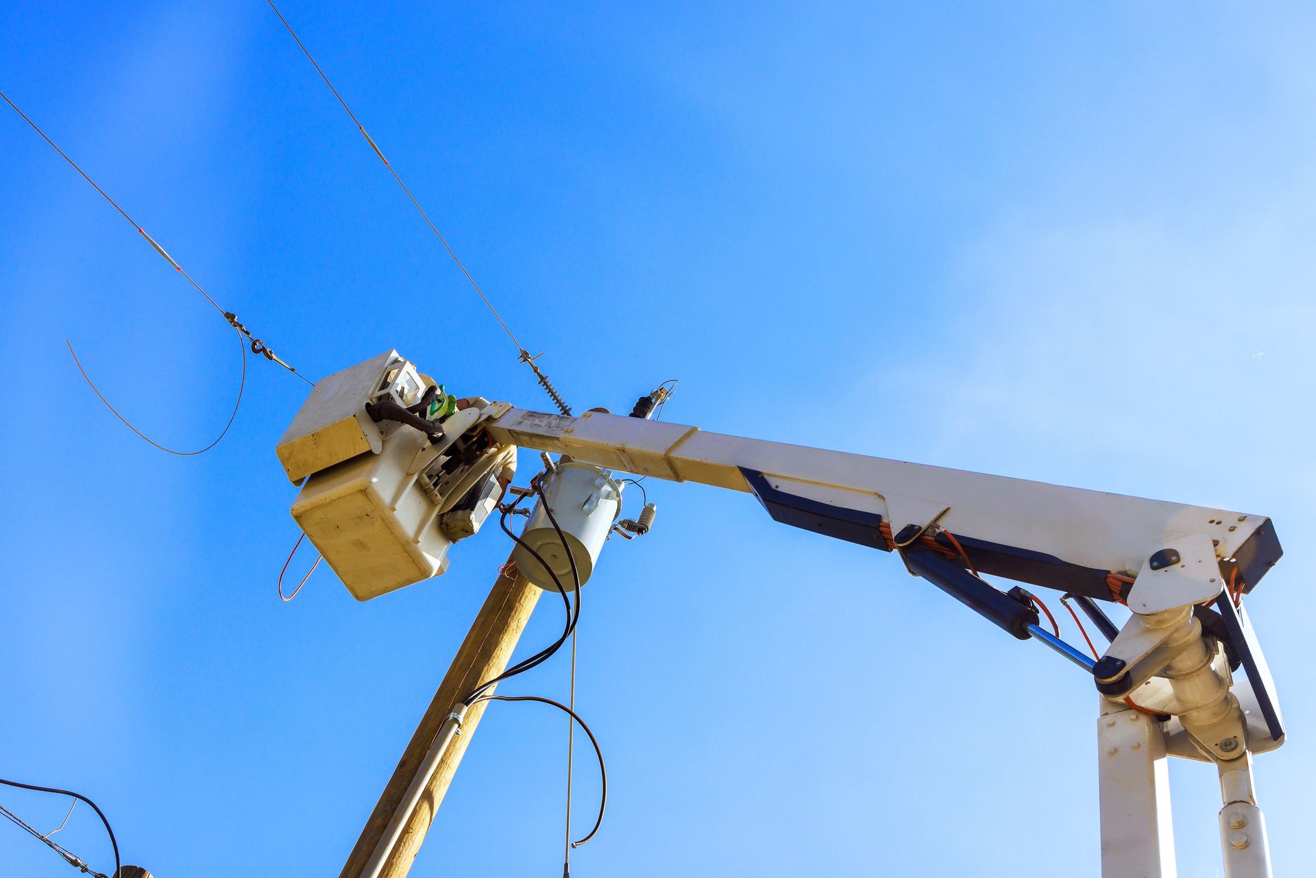 A utility vehicle with a lift servicing a street light at night. The vehicle has 