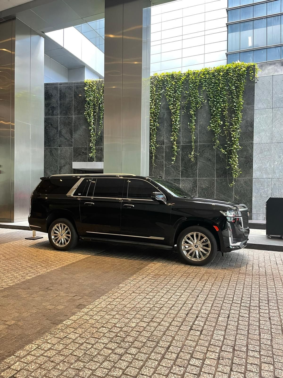 A black suv is parked in front of a building.