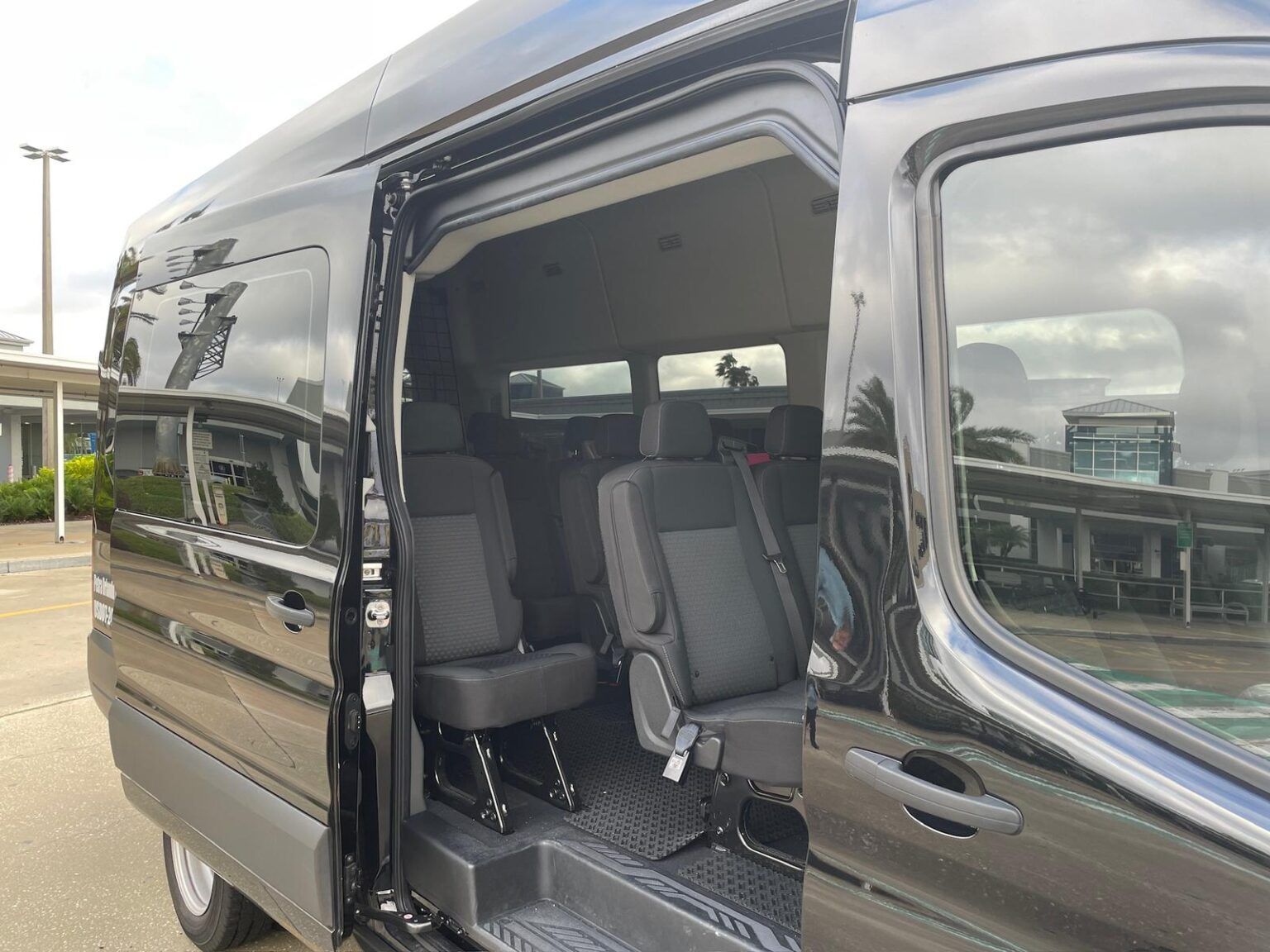 A black van with the doors open and the seats folded down.