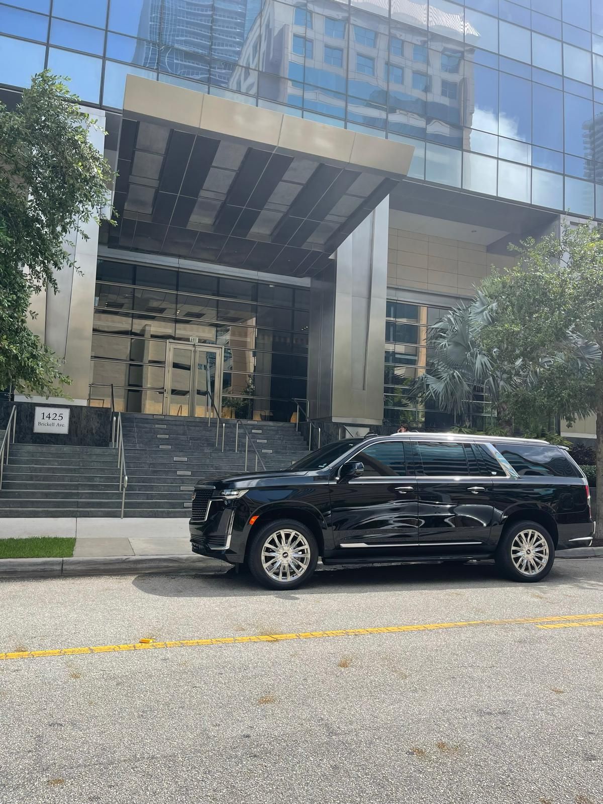 A black suv is parked in front of a building.