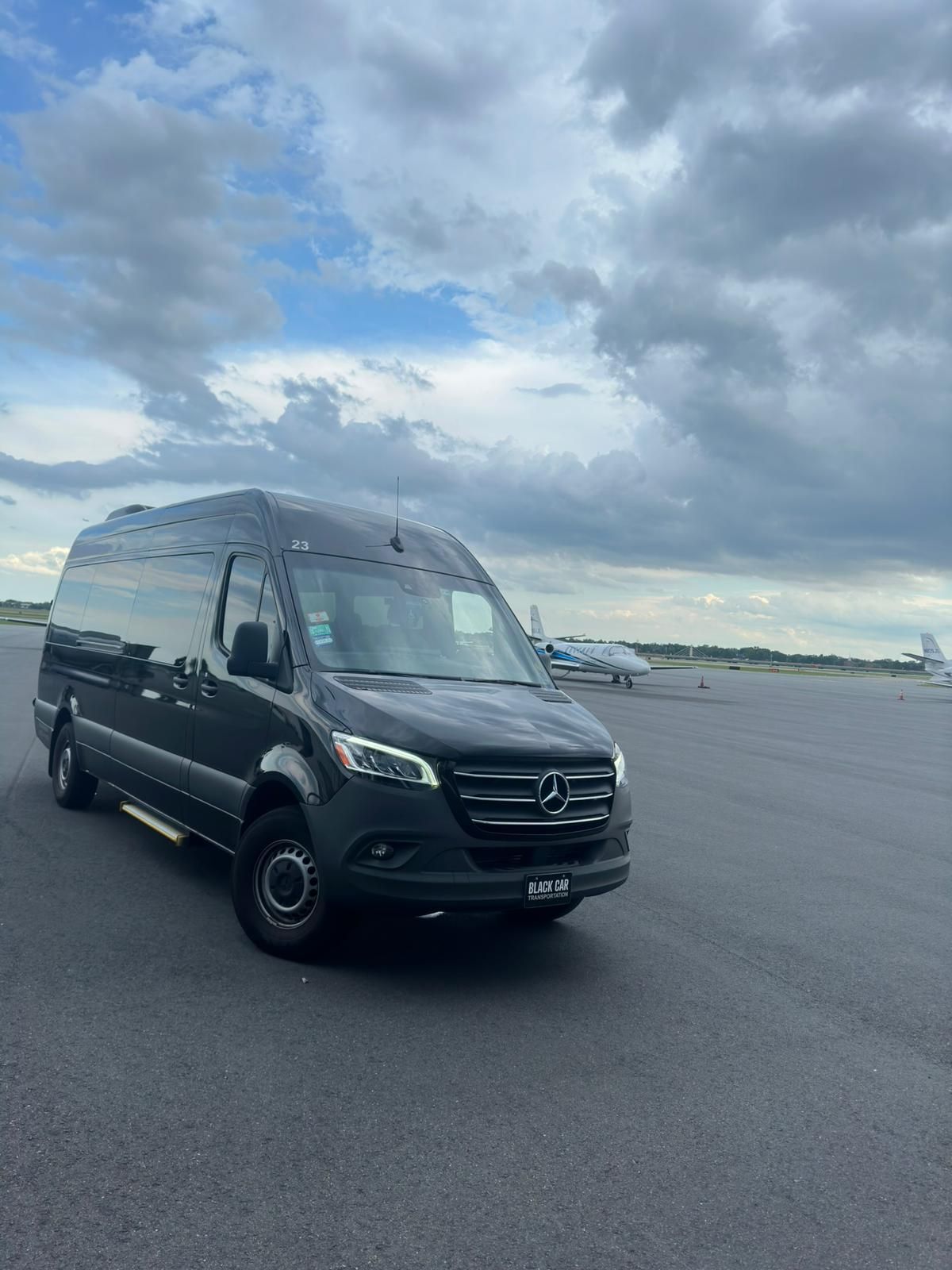 A black van is parked on the side of a road.