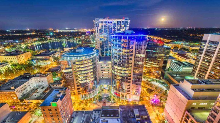 An aerial view of a city at night with lots of tall buildings.