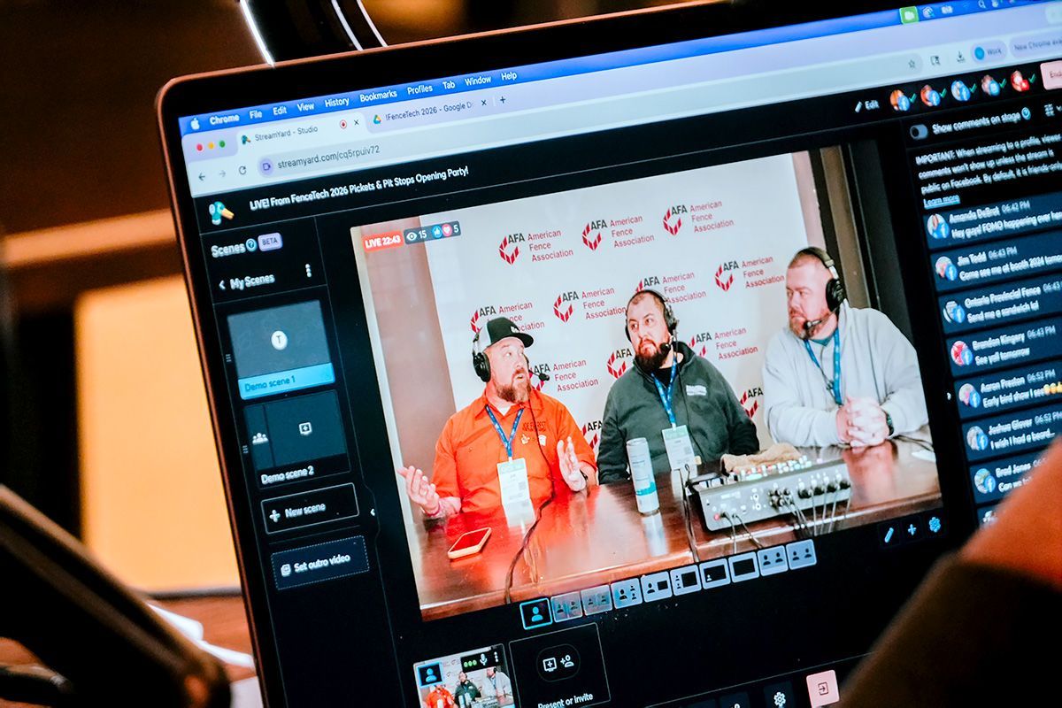 Laptop screen displaying live stream of three men with microphones at a table.