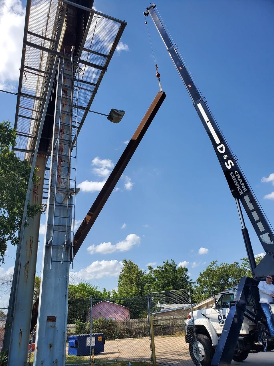 A large metal pole is being lifted by a crane.