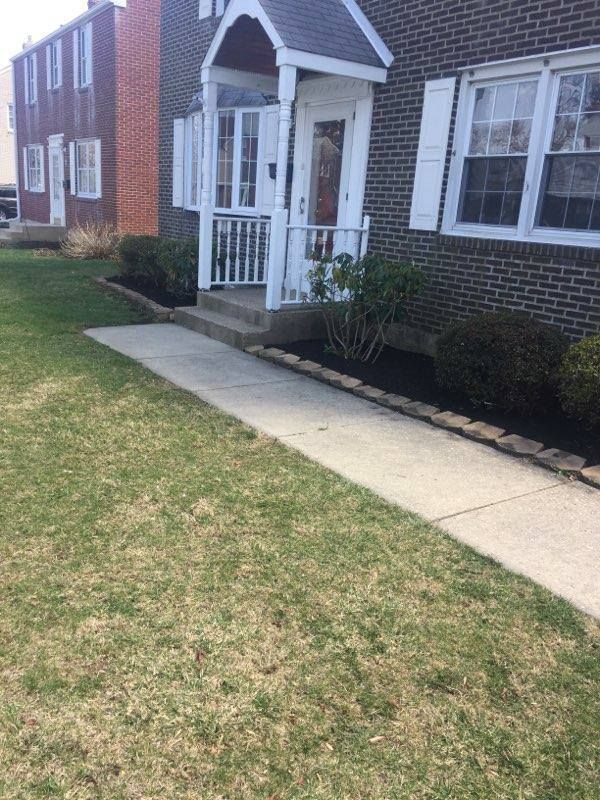 A brick house with a white porch and shutters