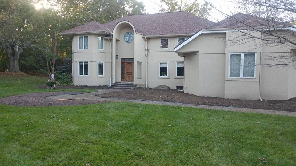 A large house with a lush green lawn in front of it.