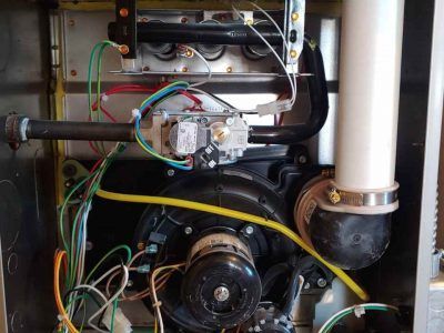 The inside of a heater with a lot of wires coming out of it.