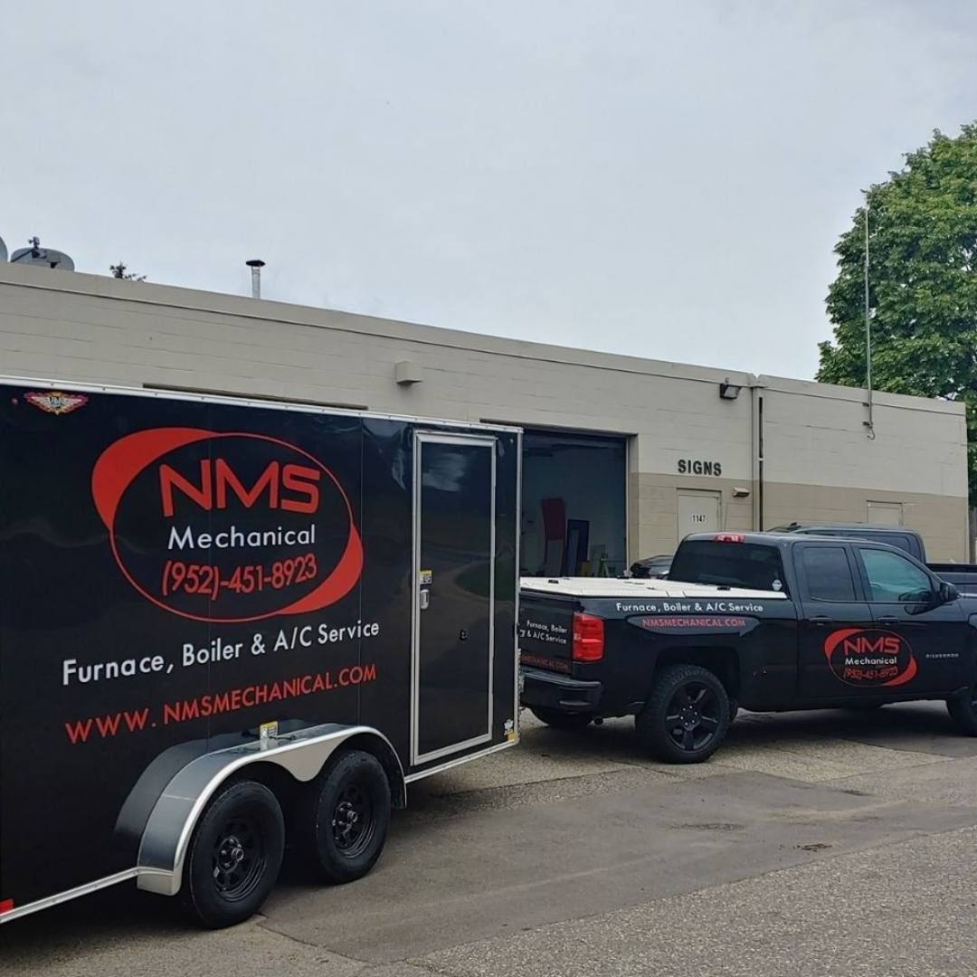 A boiler is being installed in a basement with a lot of pipes.