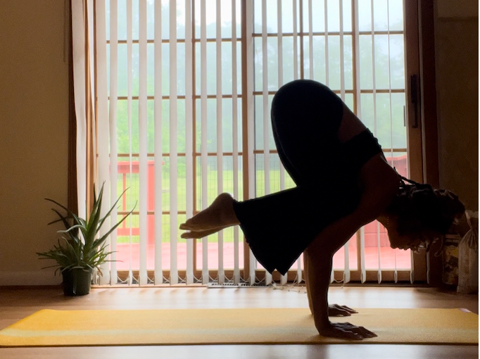 Asha Hampton sitting on a paddle board doing camel pose at the James River State Park.
