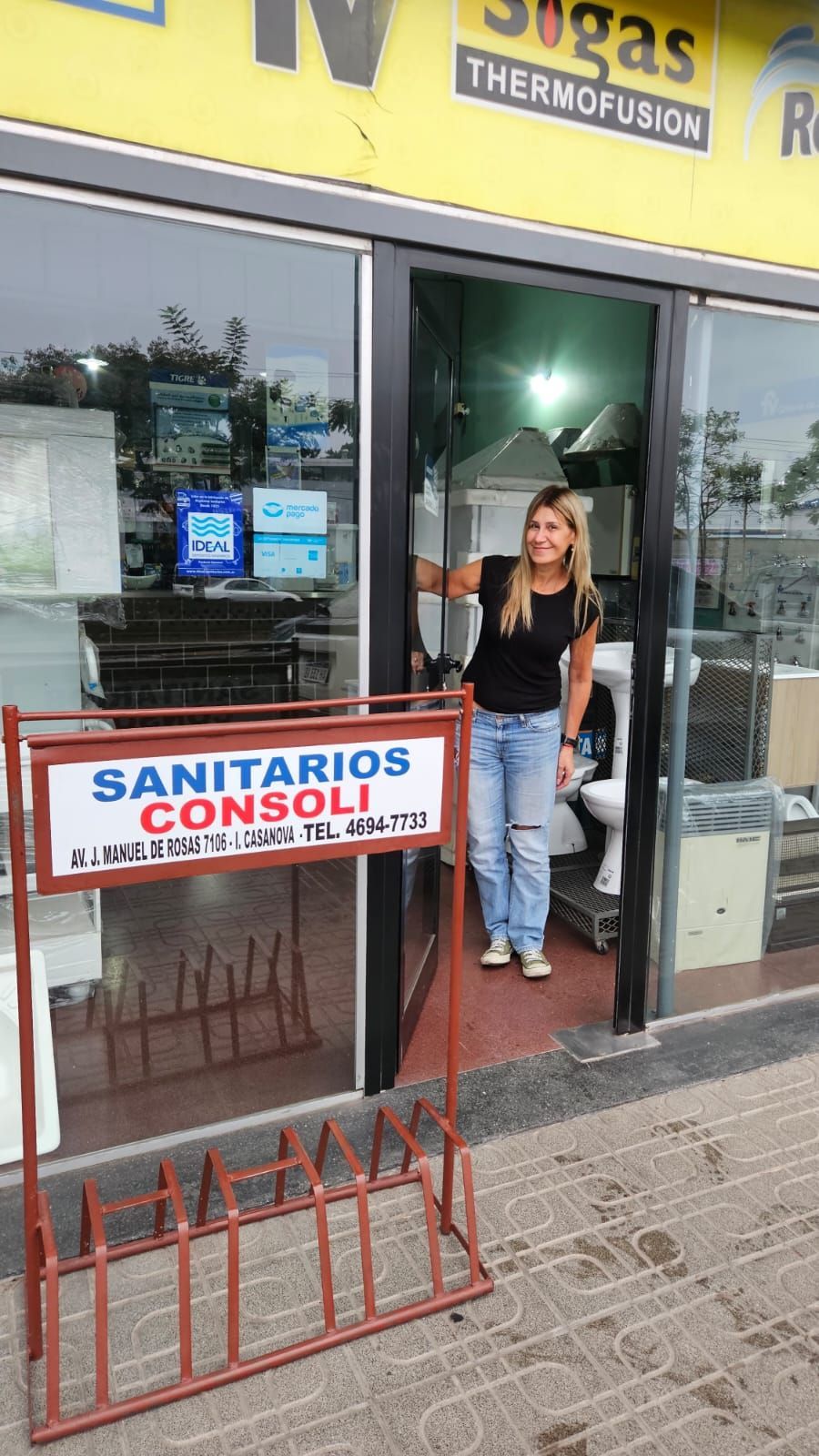 Una persona se encuentra de pie en la puerta abierta de una tienda de suministros de plomería, Sanitarios