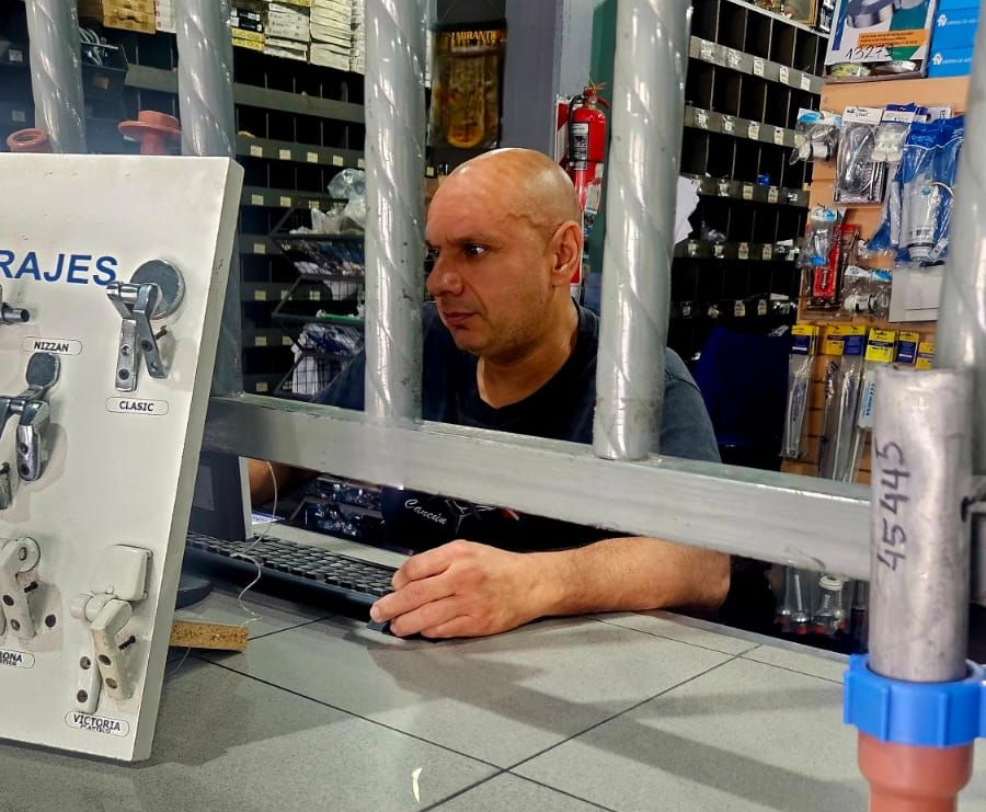 Una persona de pie detrás de un mostrador de servicio con fachada de ladrillo