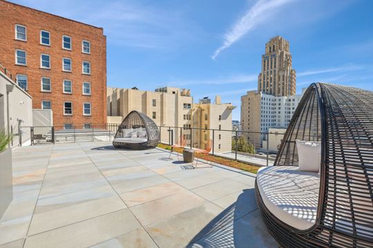 A rooftop terrace with a large building in the background