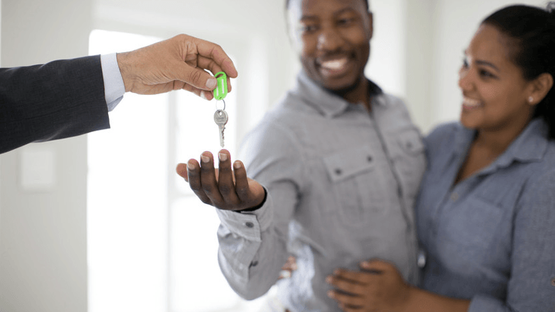 couple receiving their house keys after completing their loan