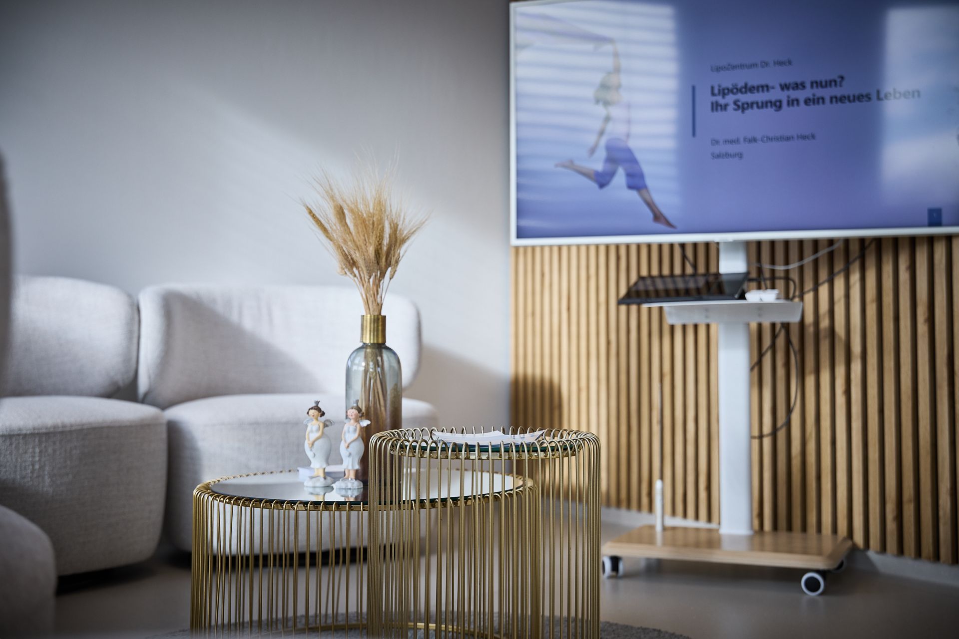 Ein Zimmer mit einer Couch, einem Tisch und einem Flachbildfernseher