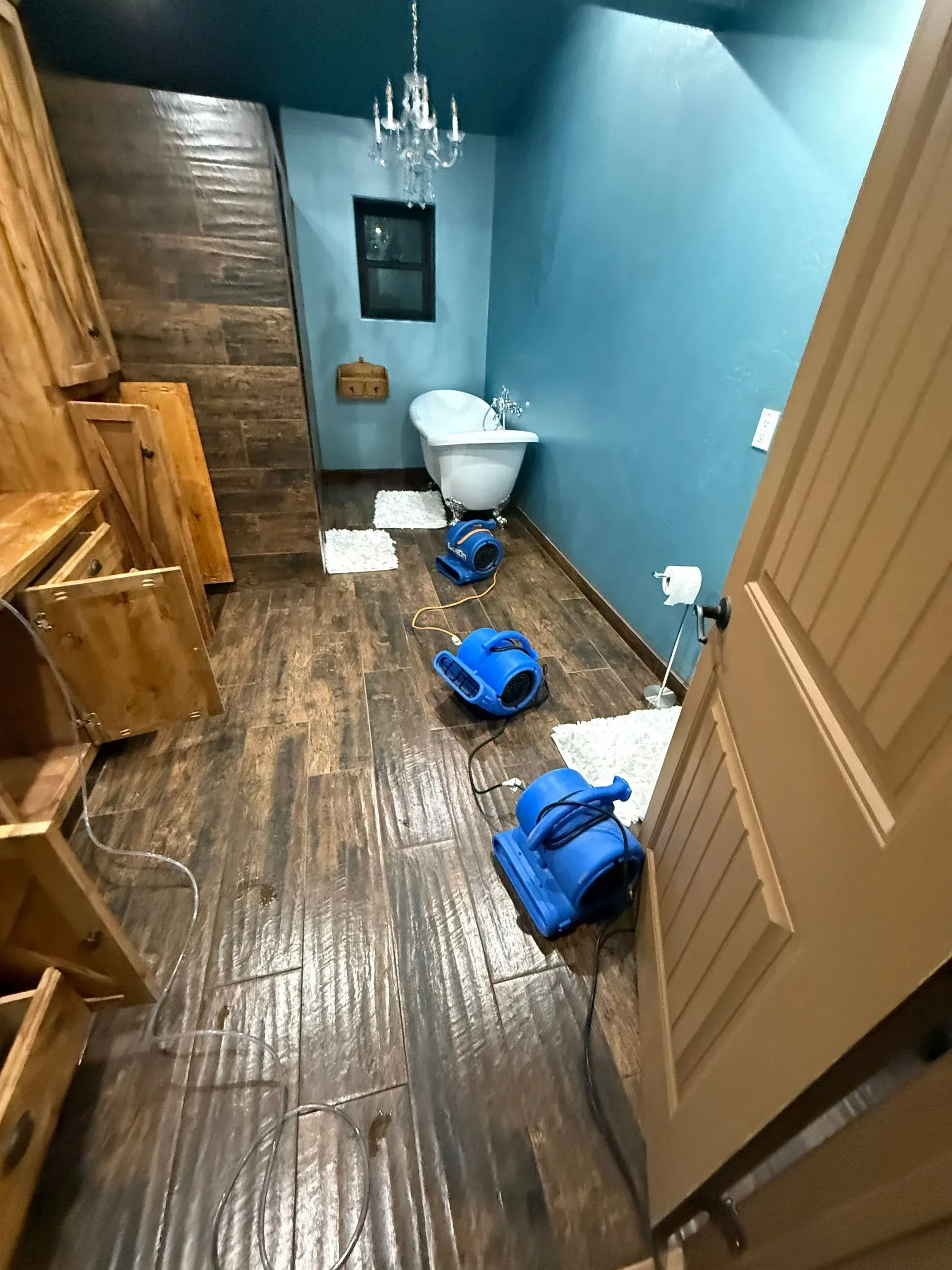 A bathroom with a tub , stairs , and a door.