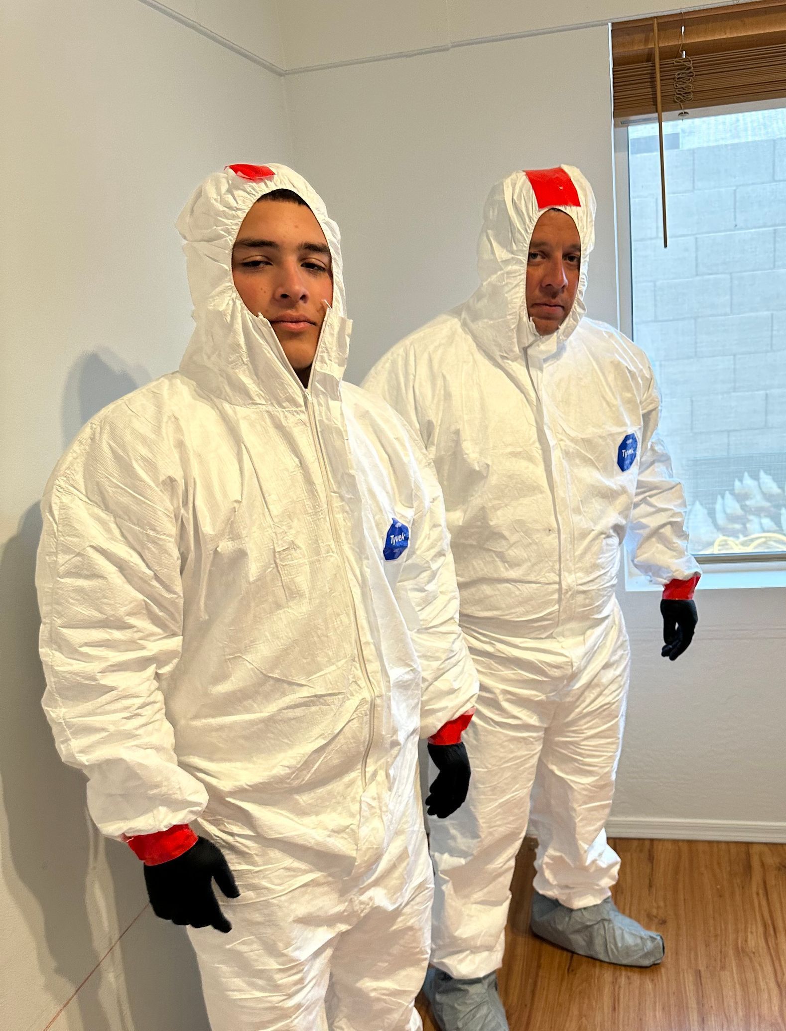 A white truck with the word triology on the side is parked in front of a house.