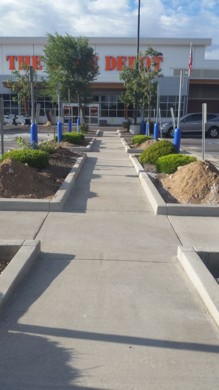 A construction worker is kneeling down on the side of a road.