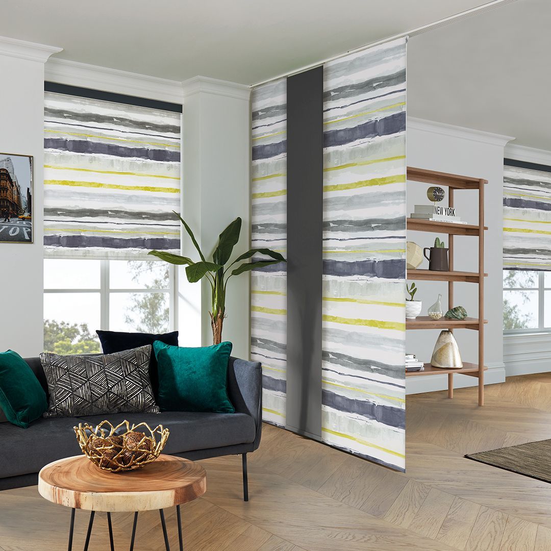 A living room with a couch , table , and striped curtains.