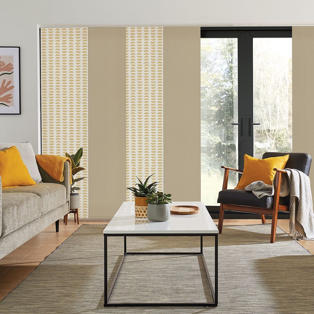 A living room with a couch , chair , coffee table and sliding glass doors.