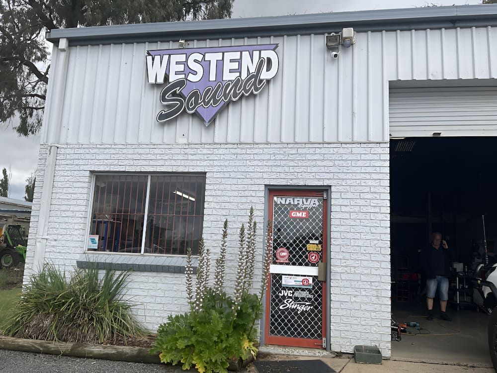 A White Brick Building With A Purple Sign That Says Westend Southern — Bones Tyres in Armidale, NSW