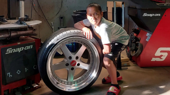 A child and a tire with a rim | VP Automotive