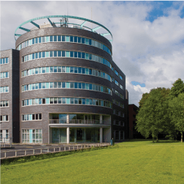 A large building with a lot of windows and a green roof