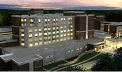 An aerial view of a large building with lots of windows lit up at night.
