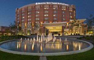 A large brick building with a fountain in front of it