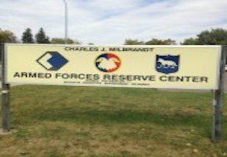 A sign for the armed forces reserve center is sitting in the grass.
