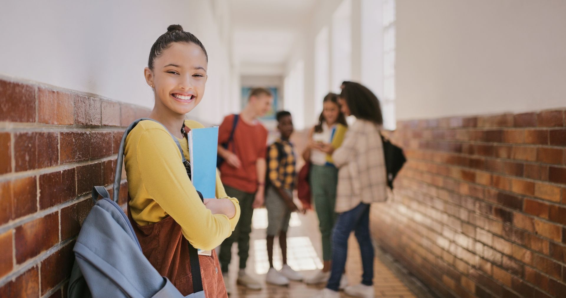 A group of students are standing in a hallway.