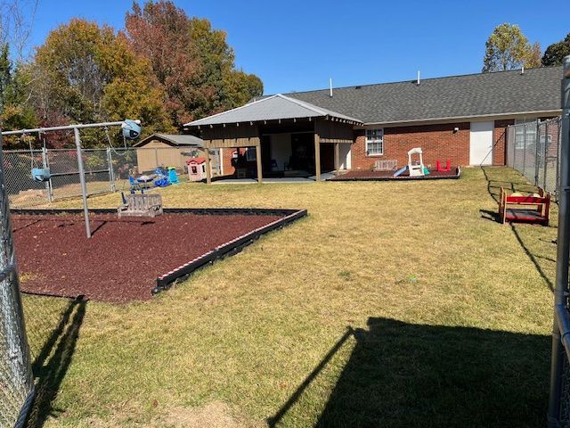 A house with a playground in front of it