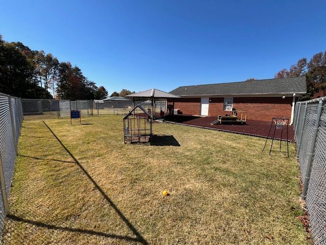 A fenced in yard with a house in the background.