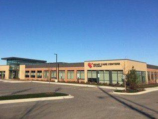A large building with a lot of windows and a parking lot in front of it.