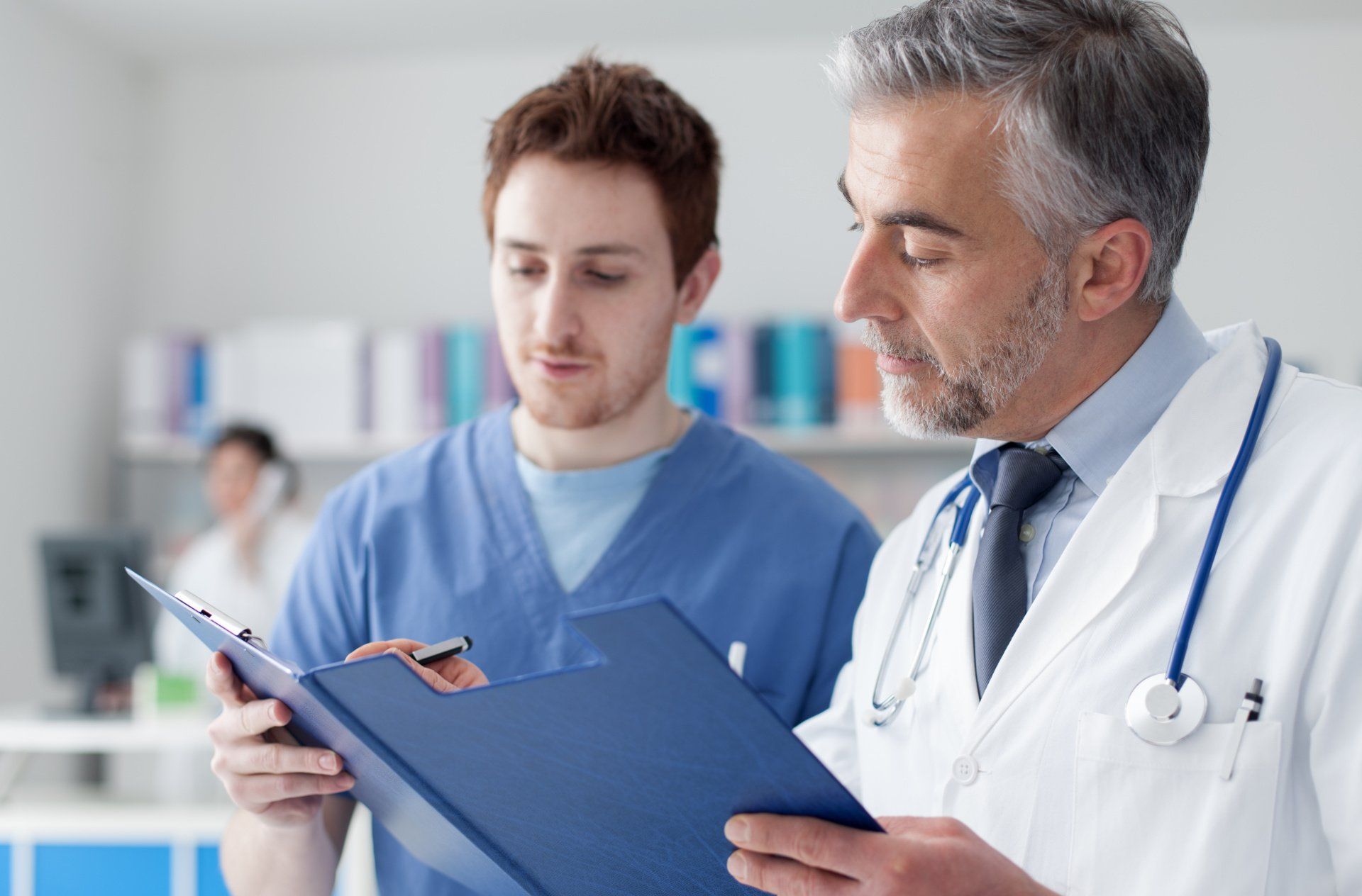 Two doctors are looking at a clipboard in a hospital.