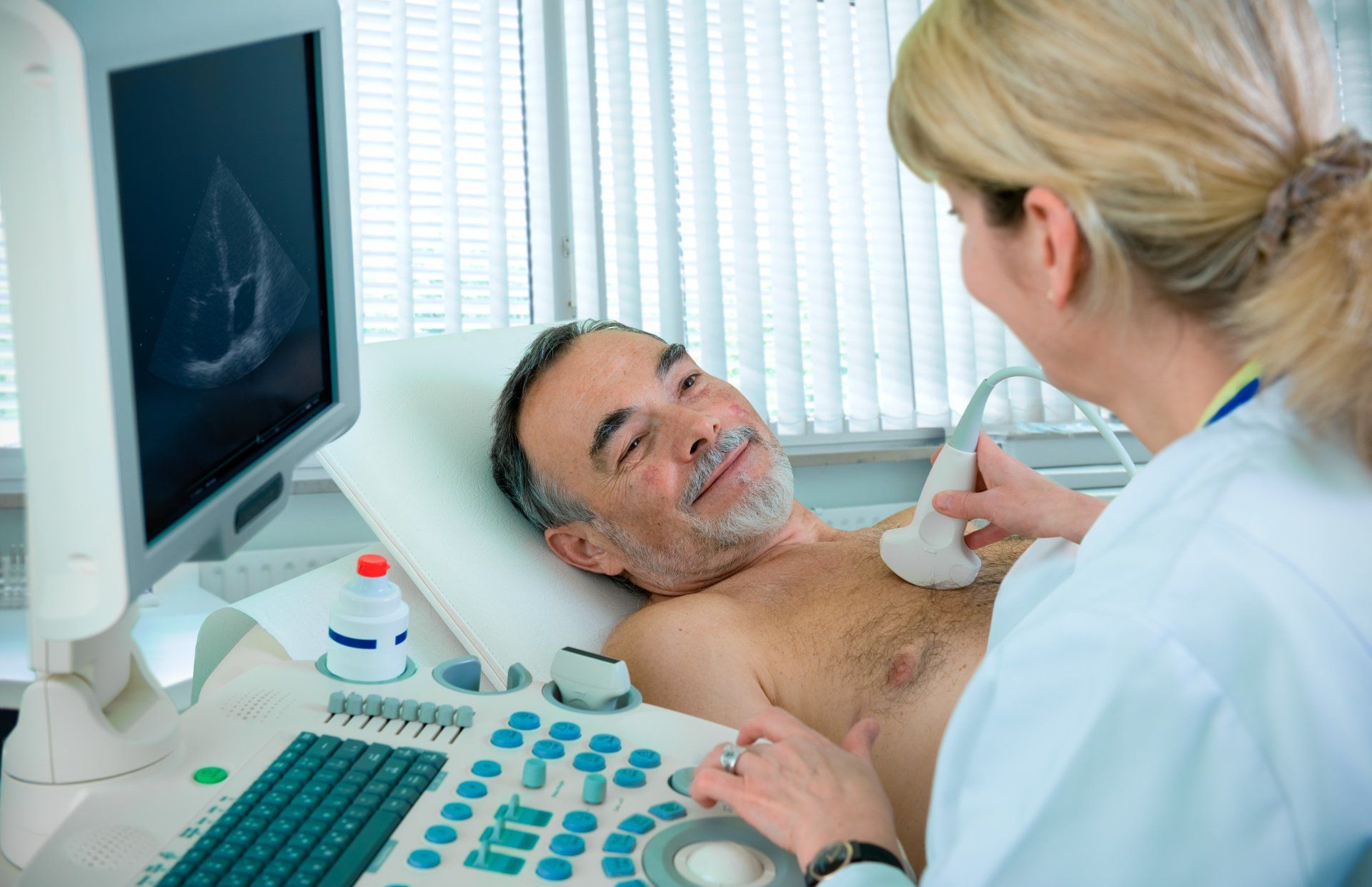A man is getting an ultrasound of his chest by a doctor.