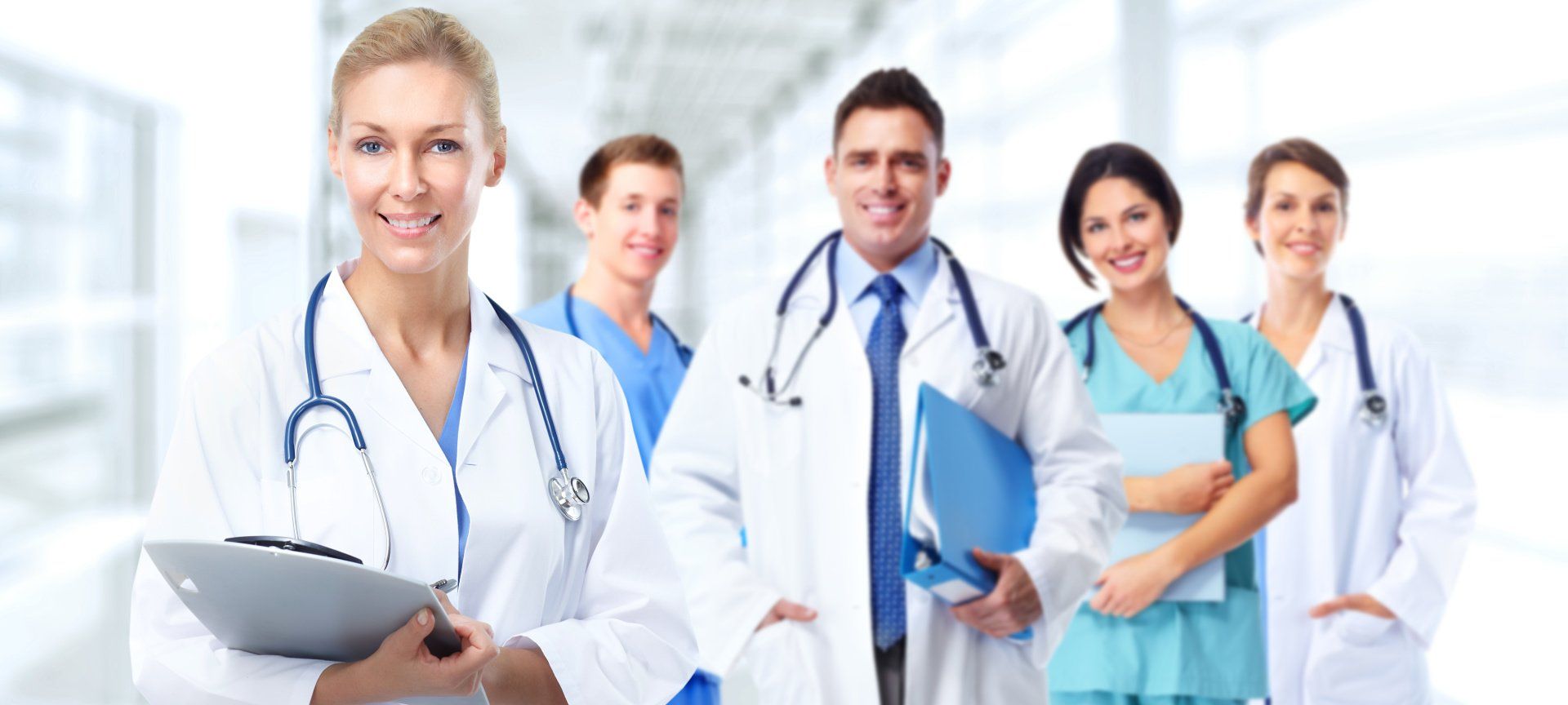 A group of doctors and nurses are posing for a picture in a hospital.