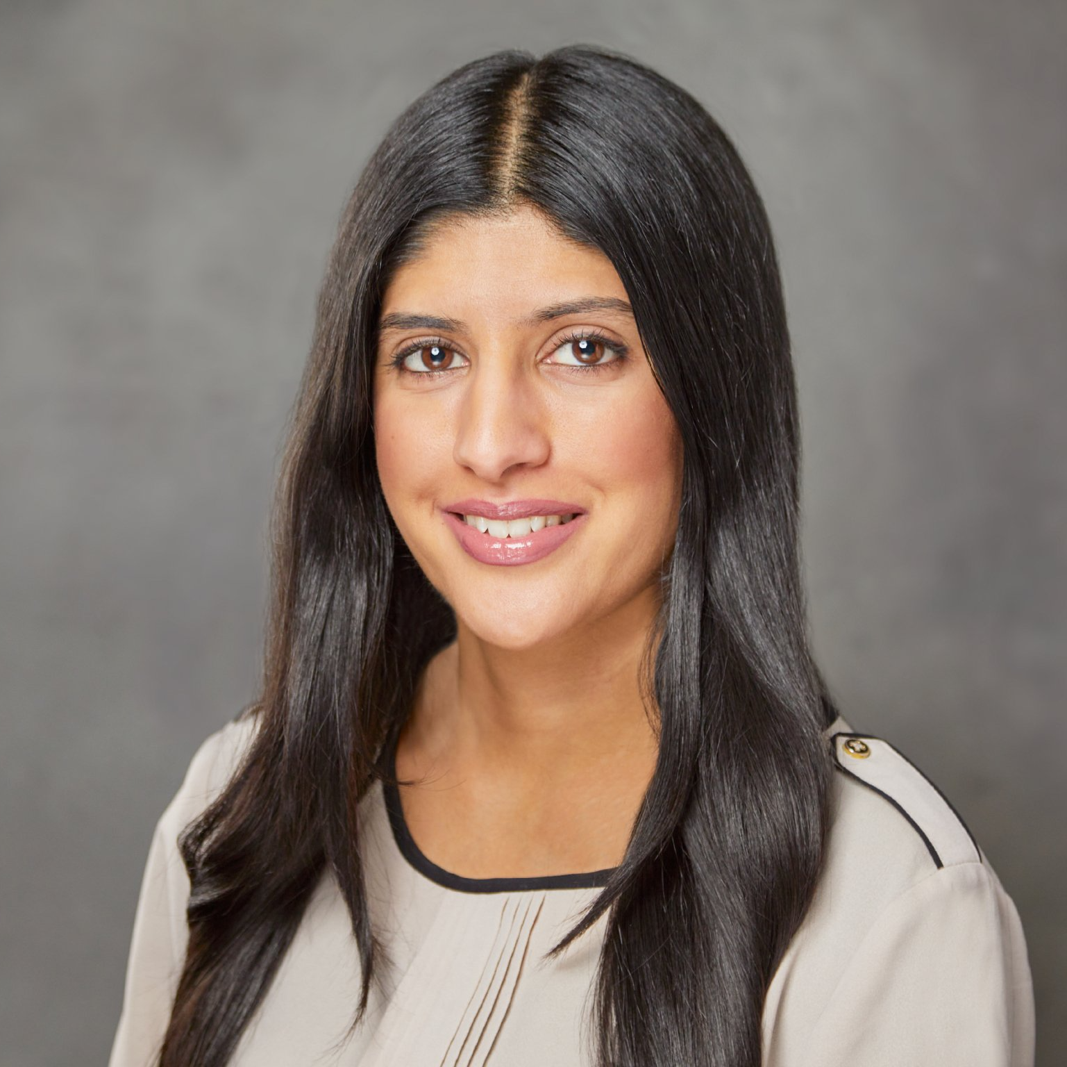 A woman with long black hair is smiling for the camera.