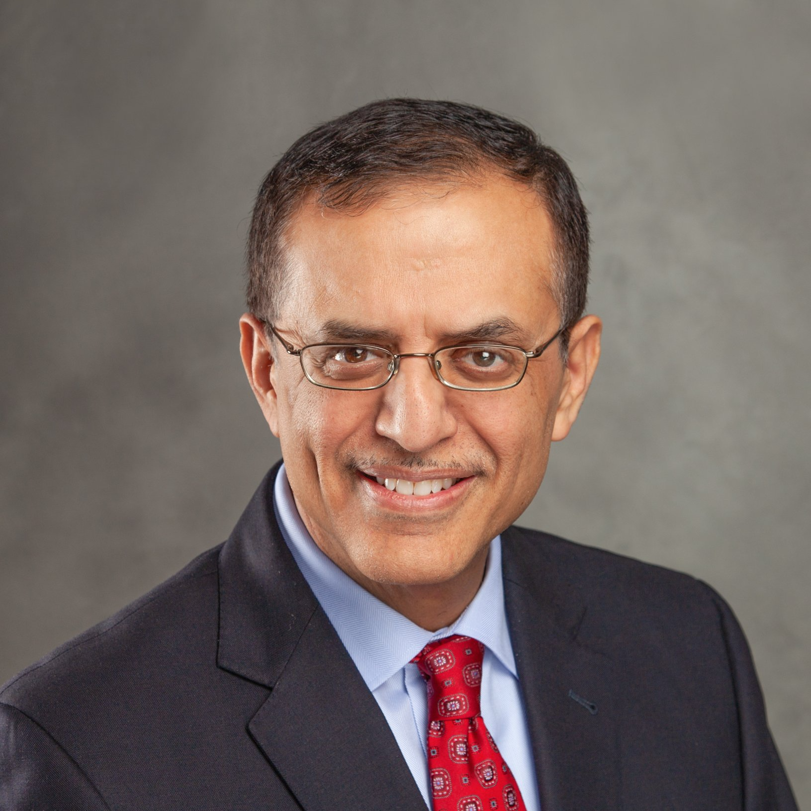 A man in a suit and tie is smiling for the camera