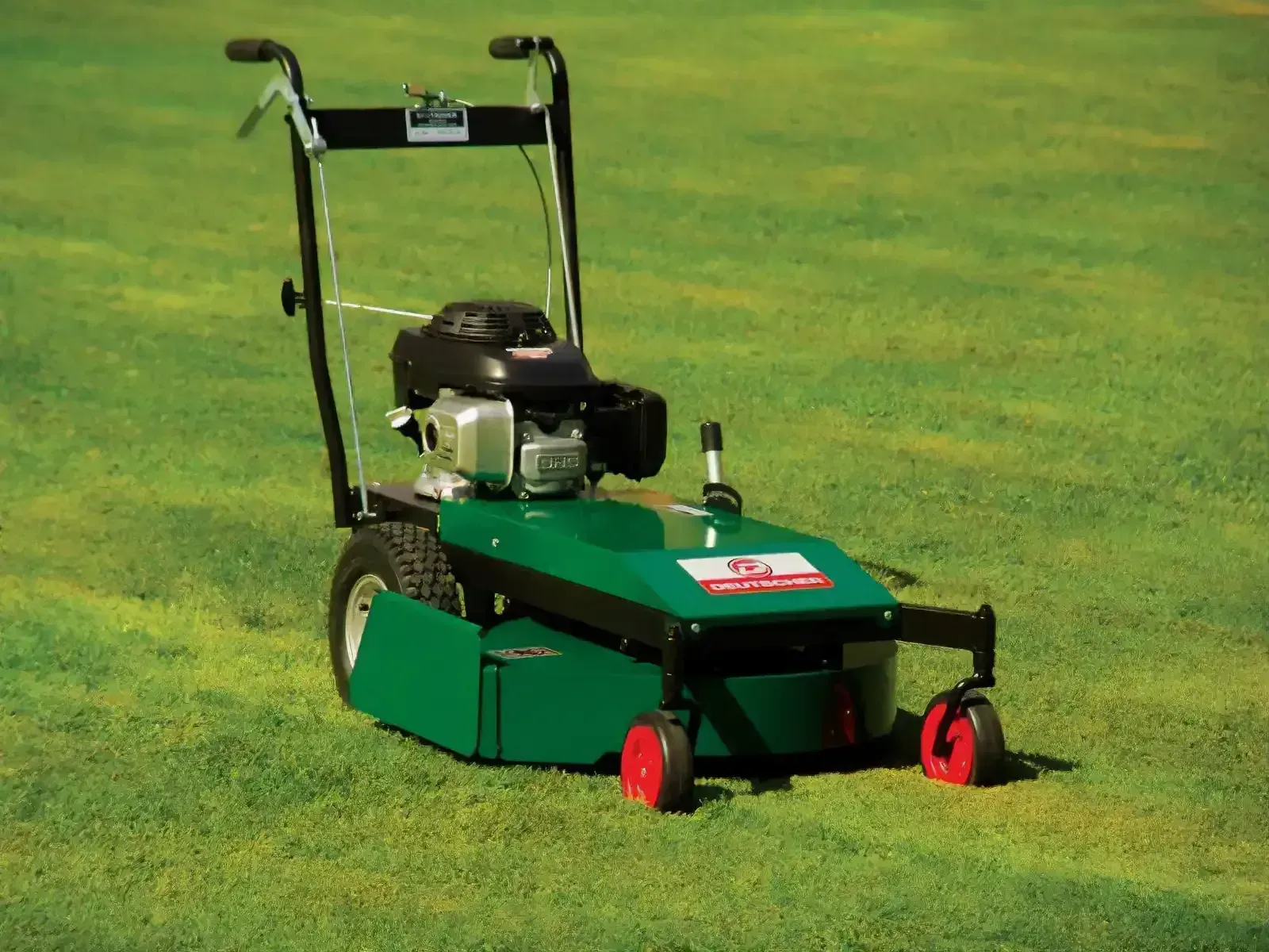 Green Lawn Mower on Grass With a Black Engine and Red Wheels — Stihl Shop Atherton In Atherton, QLD