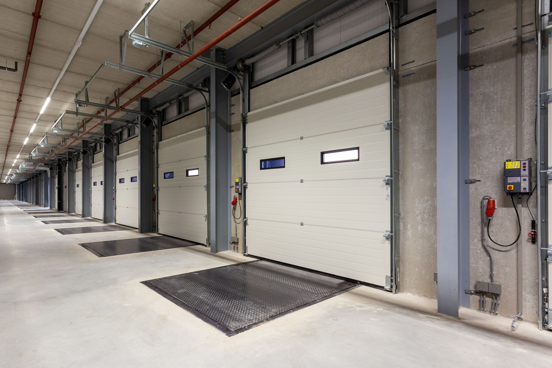 Industrial loading dock with closed commercial garage doors and dock levelers.
