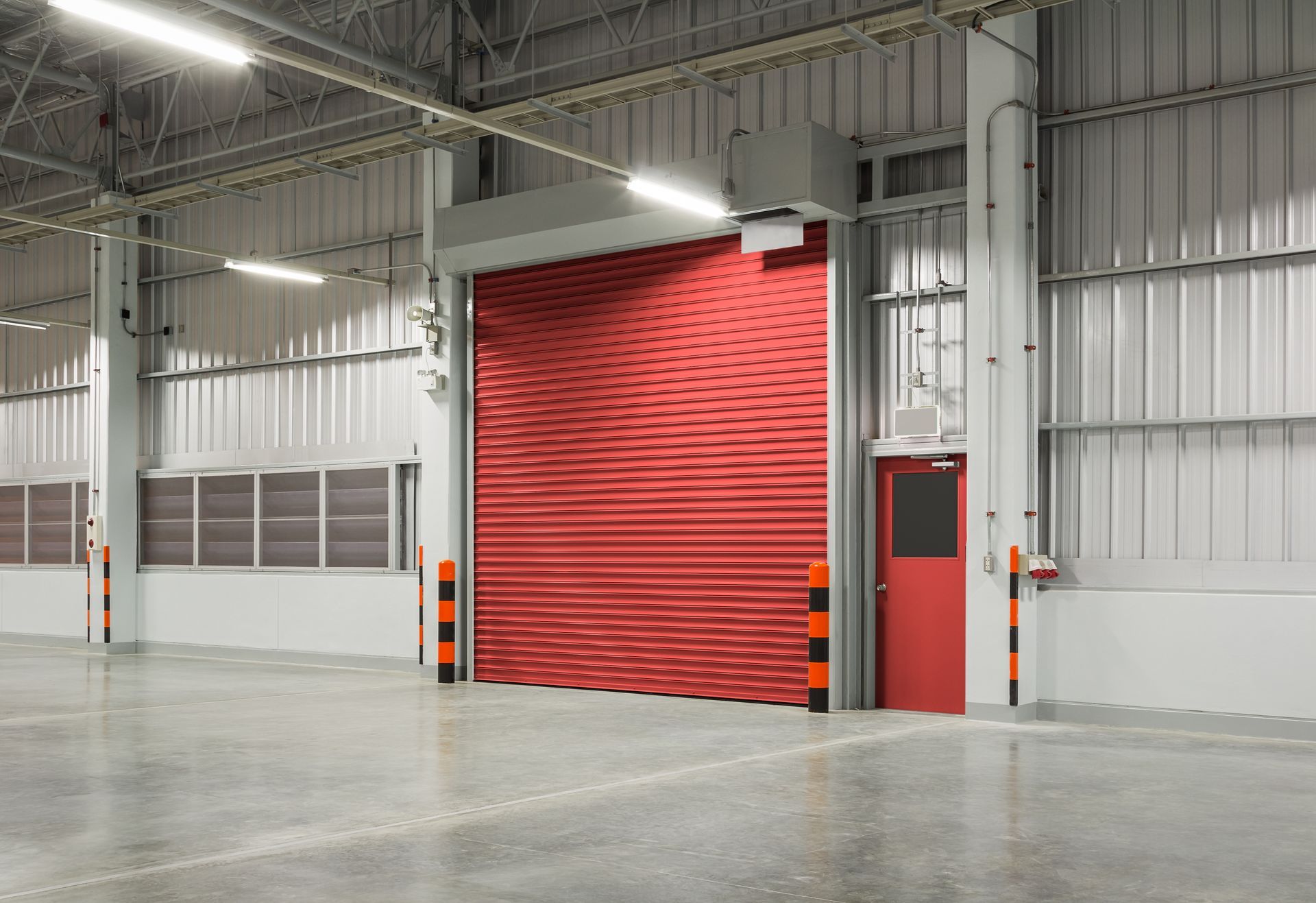 A red roller shutter from a commercial door supplier at a warehouse.