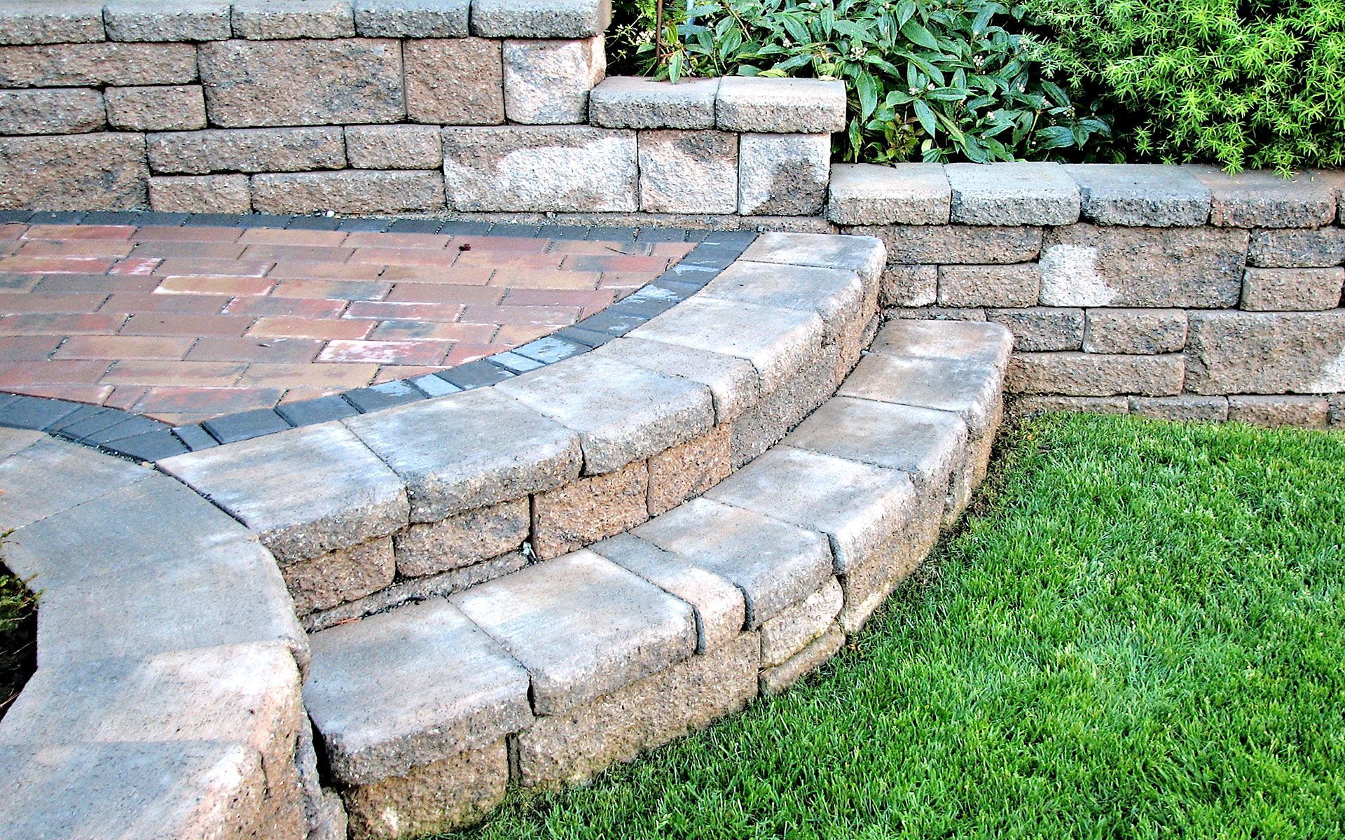 A brick wall with steps leading up to a brick patio
