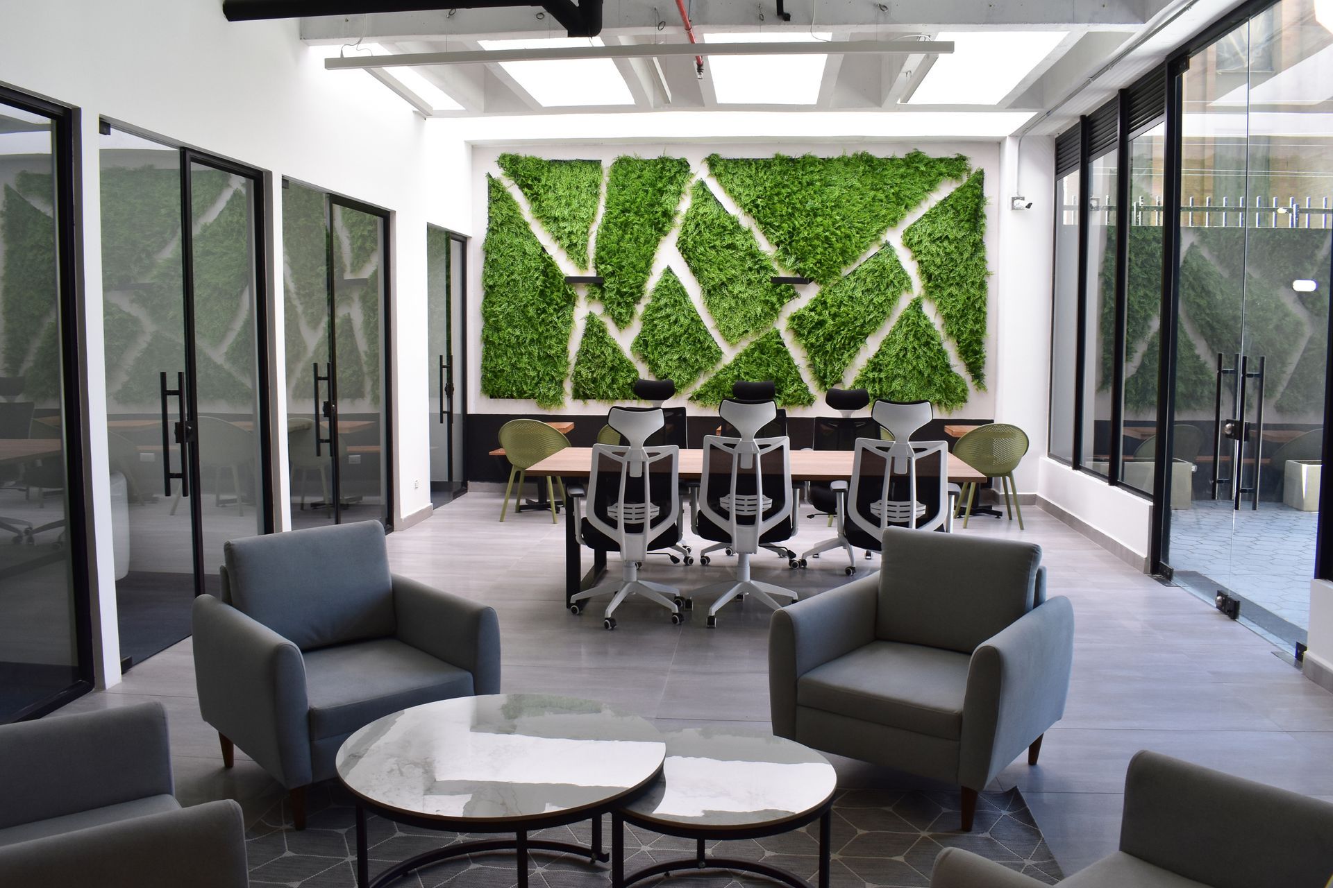 Área de trabajo compartida en hotel con coworking, con mesas amplias, sillas ergonómicas y lounge para reuniones y trabajo remoto.