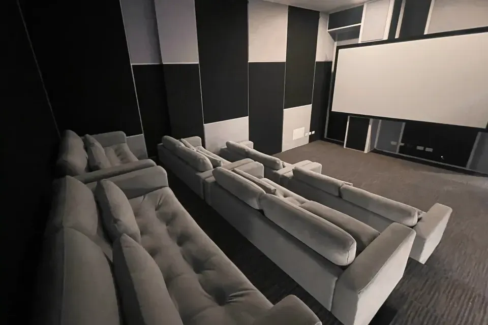 Sala de cine en VOU  Suites Bogotá, un ambiente moderno para relajarse y disfrutar de experiencias culturales sin salir del hotel.