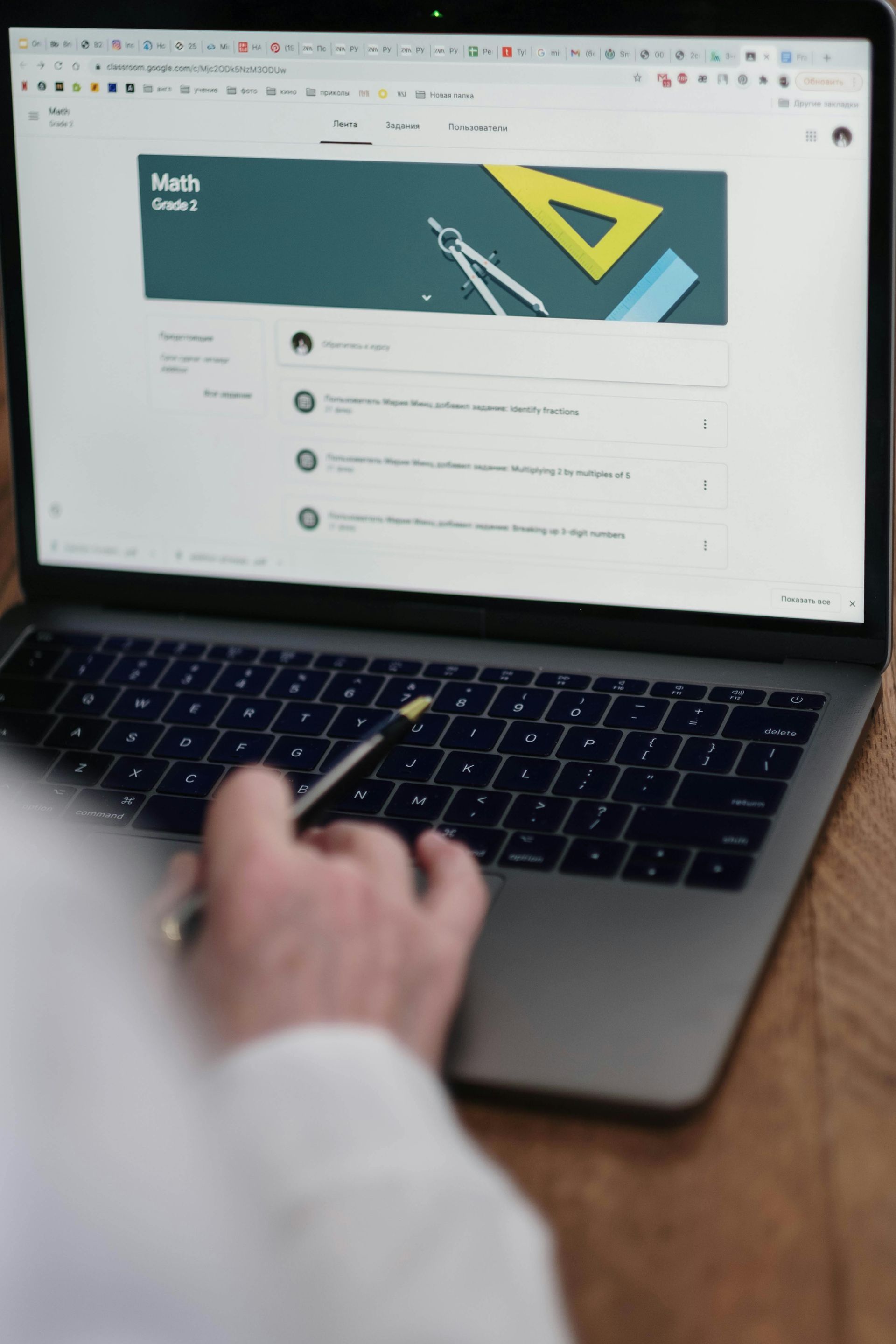 A person using a laptop to view a Google Classroom page for a math class.