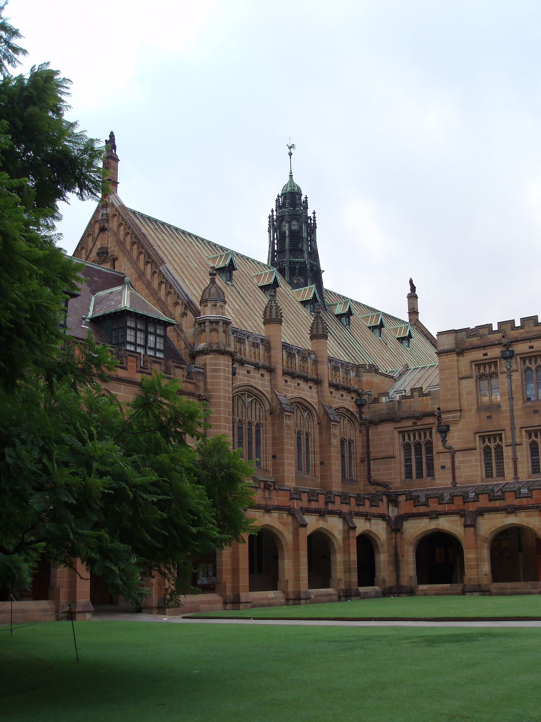 The gothic sandstone Quadrangle building at the University of Sydney, with its central spire and arched courtyard.