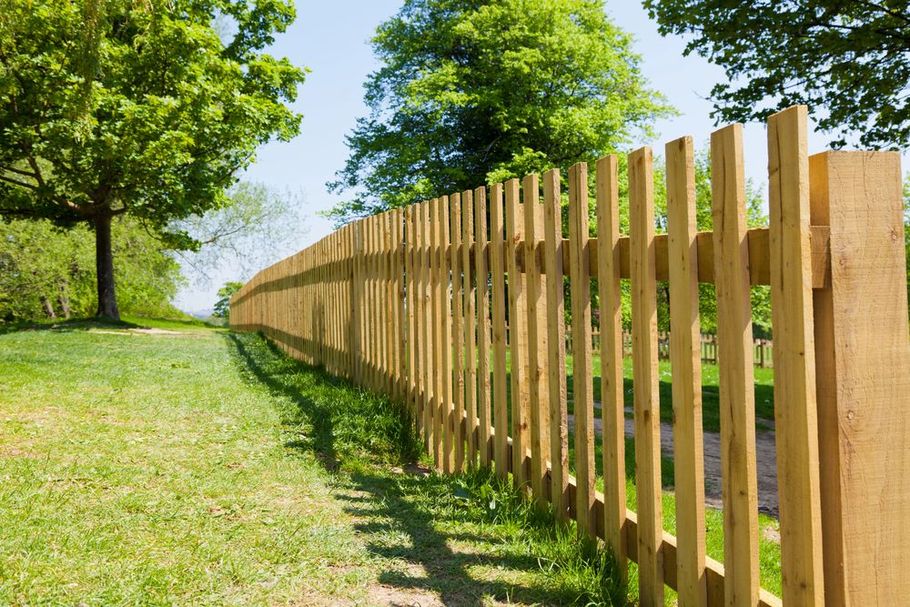 Classic wooden picket fence along a green park trail