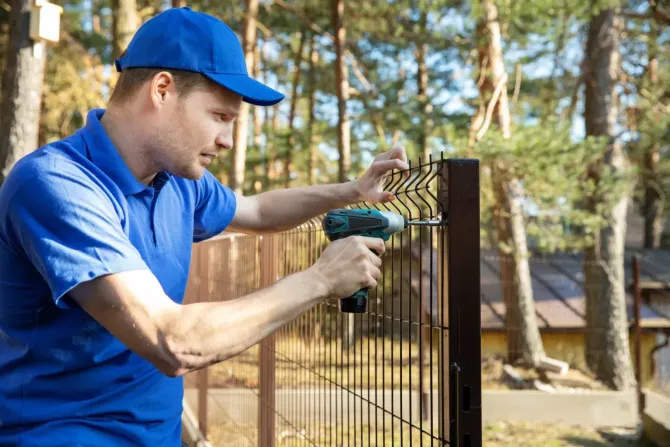 Professional installer fixing a metal security fence