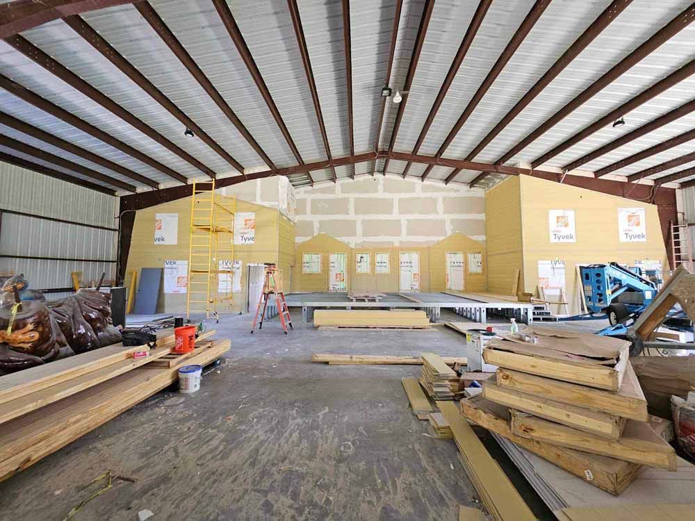 Interior of a large building under construction. Walls being built, construction materials scattered on the floor. Steel beams and metal frame.